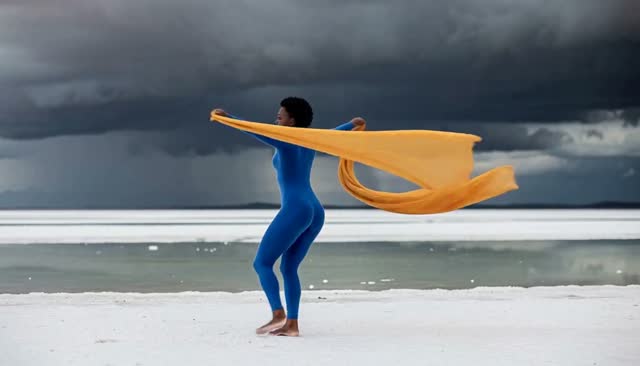 Dancer Tosses a Long Yellow Scarf on the Shore