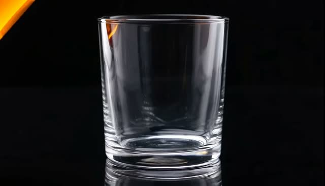 Golden liquor and ice splash in a clear glass