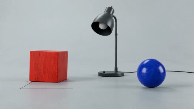 Red Cube and Blue Sphere Move Around a Lamp